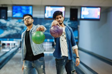 Kot gömlek bowling Club topları ellerinde tutan iki Güney Asya arkadaş.