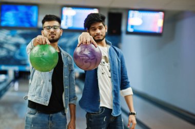 Kot gömlek bowling Club topları ellerinde tutan iki Güney Asya arkadaş.