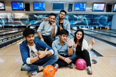 Dinlenme ve eğlence bowling Club, elindeki topları ile bowling salonu üzerinde oturan sahip beş Güney Asya halklarının grup.
