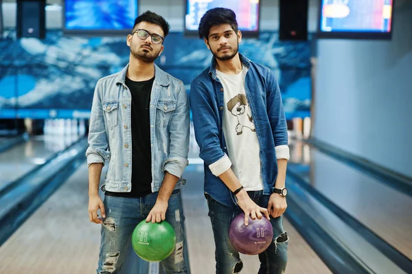 Kot gömlek bowling Club topları ellerinde tutan iki Güney Asya arkadaş.
