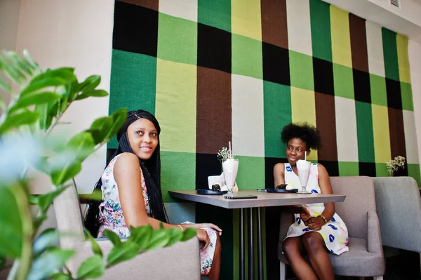 Duas amigas africanas pretas em vestidos de verão que bebem milksha — Fotografia de Stock