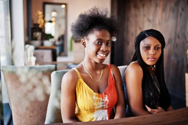 Duas amigas africanas negras em vestidos de verão sentados à mesa — Fotografia de Stock