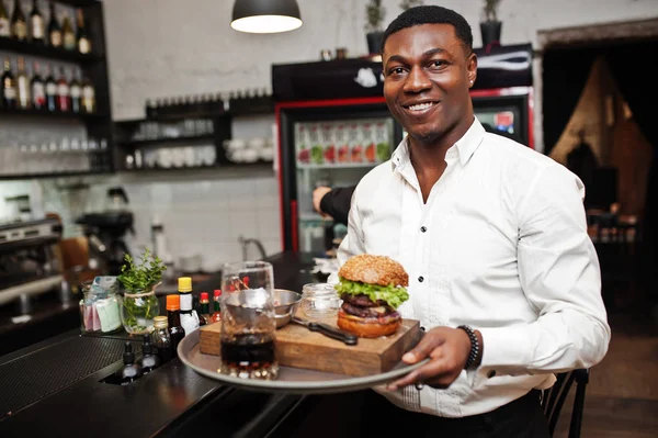 Young african american waiter man hold tray with burger at bar o