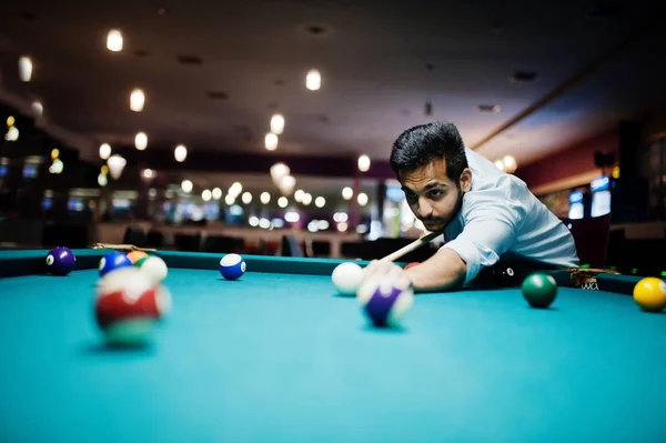 Elegante árabe homem desgaste no jeans jogar bilhar piscina no bar . — Fotografia de Stock