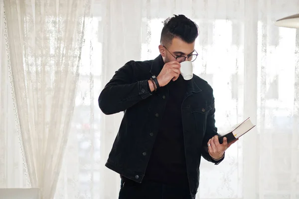 Arabische man slijtage van zwarte jeans jas en bril in café, lezen — Stockfoto