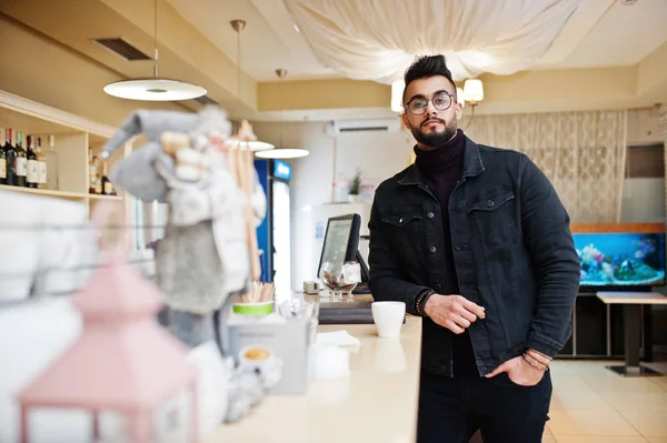 Arabische man dragen op zwarte jeans jas en bril in café drankje — Stockfoto