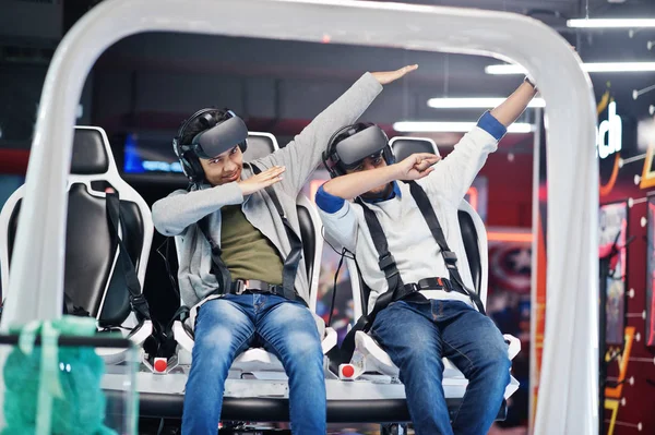 Two young indian people having fun with a new technology of a vr