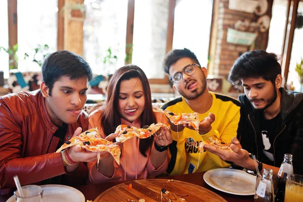 Group of asian friends eating pizza during party at pizzeria. Ha