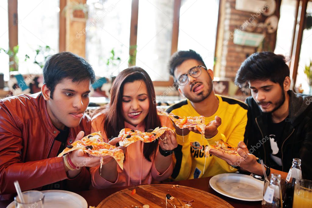 Group of asian friends eating pizza during party at pizzeria. Ha