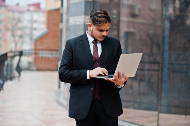 Şık Hint iş adamı el s üstünde laptop ile formal giyim