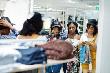 Üç Afrikalı kadın seçerek elbiselere saklayın. Alışveriş günü. ,