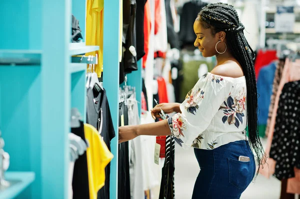 Afrikai nő választott ruhát tárolja. Bevásárló nap. — Stock Fotó