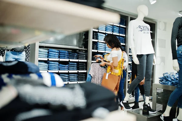 Drei Afrikanerinnen, die Kleidung im Geschäft aussuchen. Einkaufstag. die — Stockfoto
