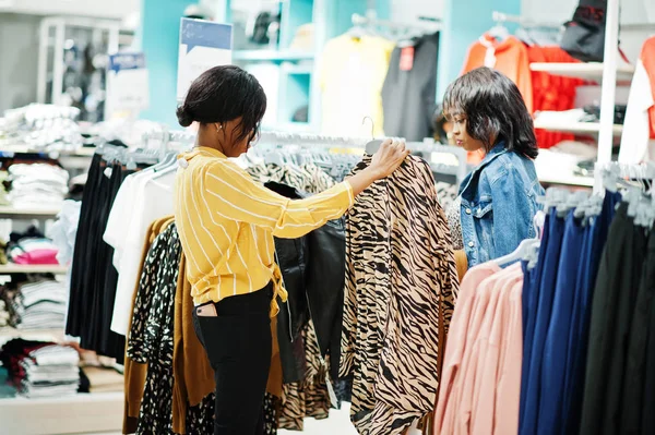 Due donne africane che scelgono vestiti al negozio. Giornata dello shopping . — Foto Stock