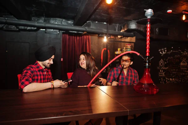 Group of indian friends sitting at lounge bar, smoke hookah and — Stock Photo, Image