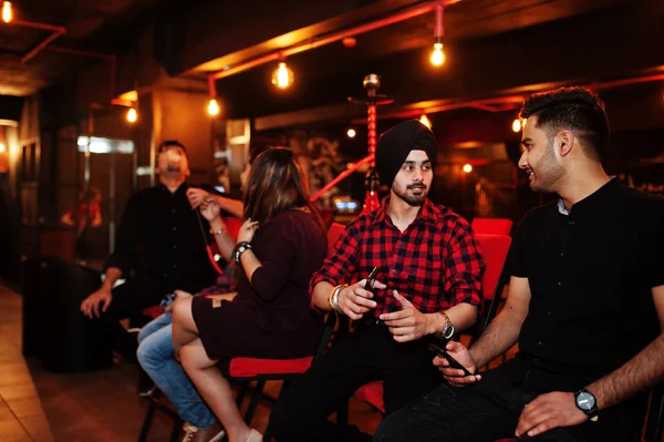 Groep Indiase vrienden zitten in Lounge Bar, rook waterpijp en — Stockfoto