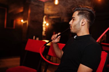 Asya adam Smoke nargile ve sahip dinlenme at Lounge Bar. 