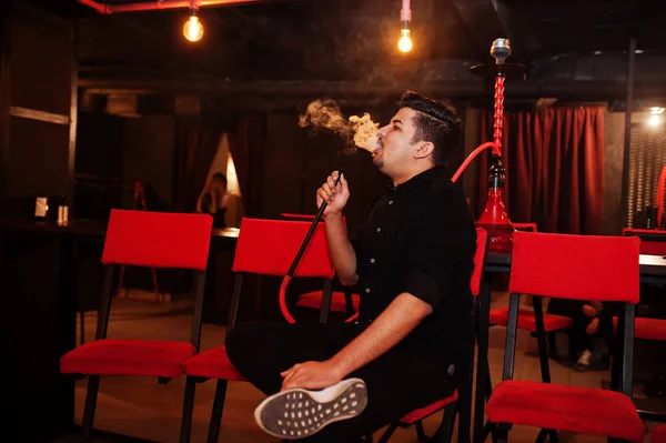 Asiático hombre humo hookah y tener descanso en lounge bar . — Foto de Stock