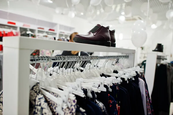 Conjunto de ropa femenina en los bastidores con zapatos en la tienda de ropa — Foto de Stock