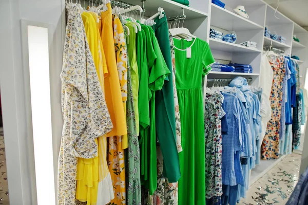 Conjunto de ropa de color verde femenino en los bastidores en la ropa s — Foto de Stock