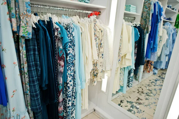 Conjunto de ropa de color azul femenino en los bastidores y estantes en — Foto de Stock