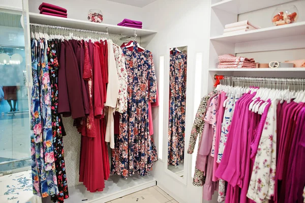 Conjunto de ropa de color rosa femenino en los bastidores y estantes en — Foto de Stock