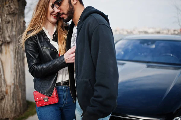 Coole multirassische Paar Umarmungen zusammen gegen schwarz elegant spor — Stockfoto