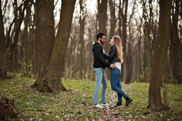 Liebesgeschichte eines coolen multirassischen Paares im Frühlingswald. — Stockfoto
