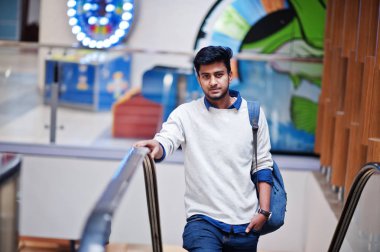 Genç Asya adam ile Backpack hamle üzerinde yürüyen merdiven at Mall.