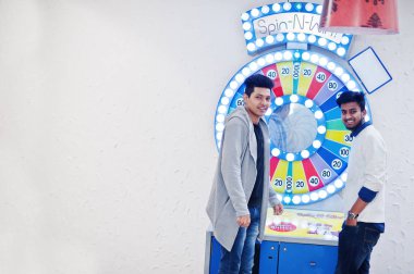 İki Genç Asyalı adamlar piyango büyük kazanmak için servet tekerlek oynamak