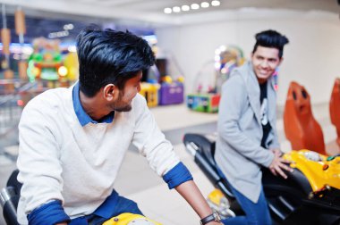 İki Asyalı adamlar hız binici arcade oyun motosiklet RAC üzerinde rekabet