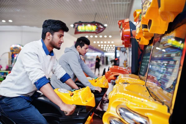 Deux asiatique les gars rivaliser sur vitesse rider arcade jeu moto rac — Photo