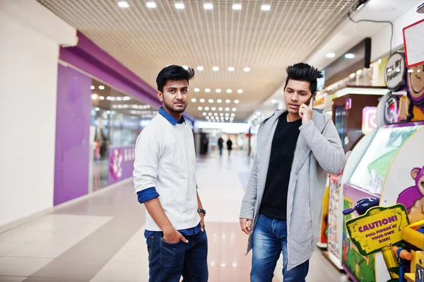 İki Asya çocuklar simülatörü oyun parkı üzerinde poz. Bunlardan biri speakin