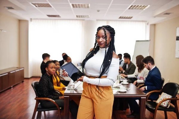 Face of handsome african business woman, holding tablet on the b