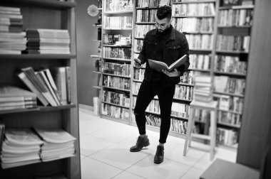 Hangi kullanım, gadget veya kitaplar? Uzun boylu akıllı Arap öğrenci adam, üzerinde Wear