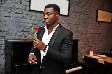 Siyah takım elbiseli güçlü güçlü afro-amerikan adam çiçek koklamak 