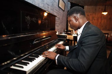 Siyah takım elbiseli güçlü güçlü afro-amerikan adam piyano çalmak.
