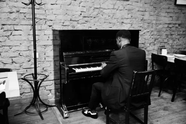 Back of strong powerful african american man in black suit play