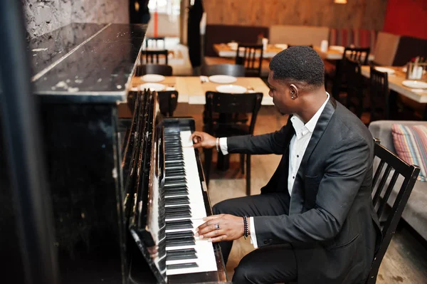 Forte potente afro americano uomo in abito nero suonare il pianoforte . — Foto Stock