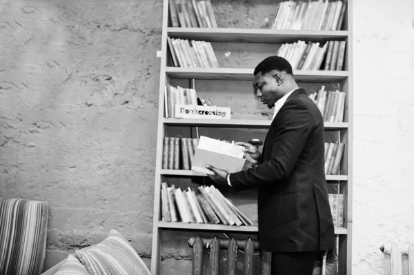 Forte poderoso homem afro-americano em terno preto ler livro aga — Fotografia de Stock