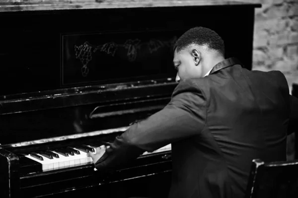 Back of strong powerful african american man in black suit play