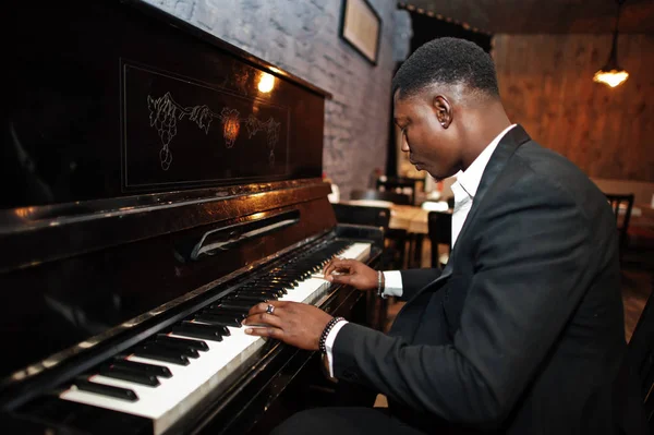 Silny potężny African American Man w czarnym garniturze grać na pianinie. — Zdjęcie stockowe