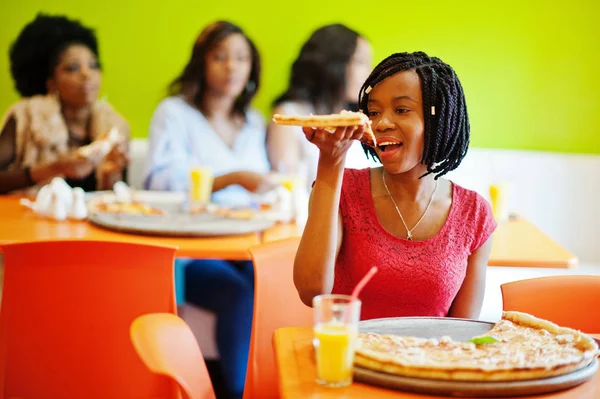 Mulher africana com pizza sentada no restaurante contra a pele escura — Fotografia de Stock