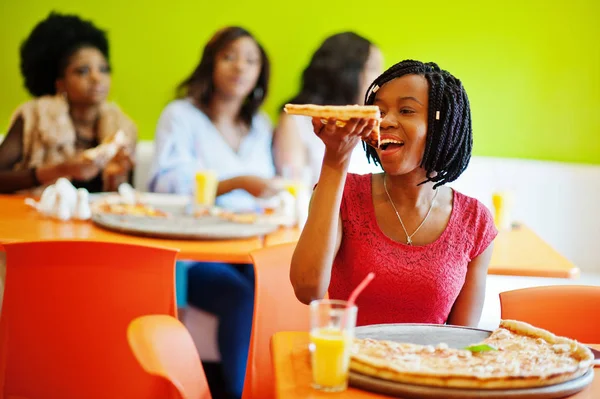 Mulher africana com pizza sentada no restaurante contra a pele escura — Fotografia de Stock