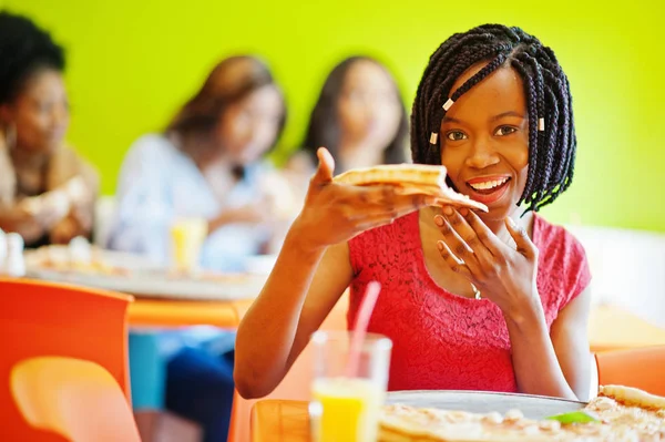 Mulher africana com pizza sentada no restaurante contra a pele escura — Fotografia de Stock