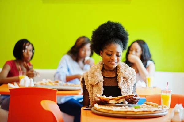 Mulher africana com pizza sentada no restaurante contra a pele escura — Fotografia de Stock