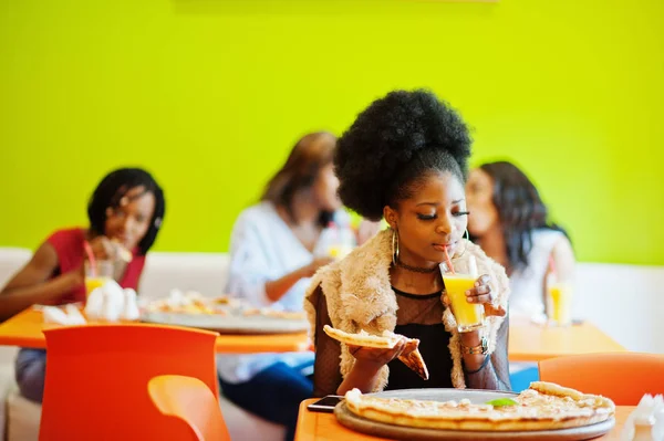 Mulher africana com pizza sentado no restaurante e beber suco a — Fotografia de Stock