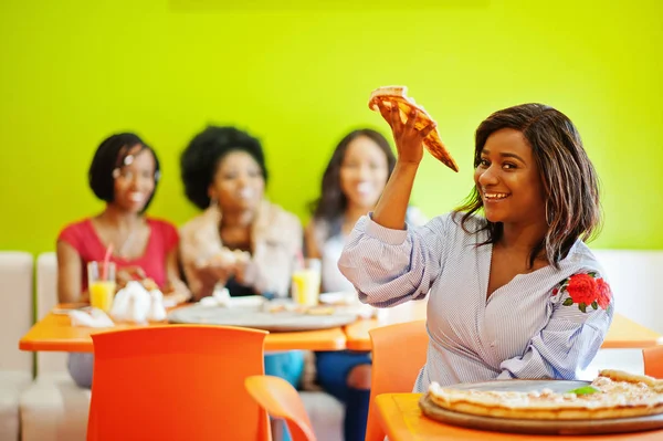 Mulher africana com pizza sentada no restaurante contra a pele escura — Fotografia de Stock