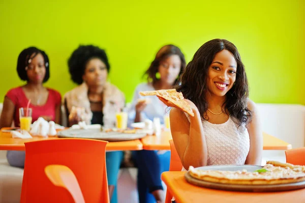 Mulher africana com pizza sentada no restaurante contra a pele escura — Fotografia de Stock