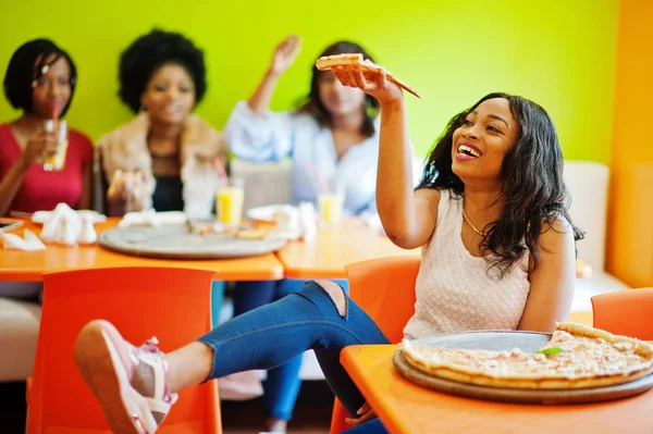 Mulher africana com pizza sentada no restaurante contra a pele escura — Fotografia de Stock